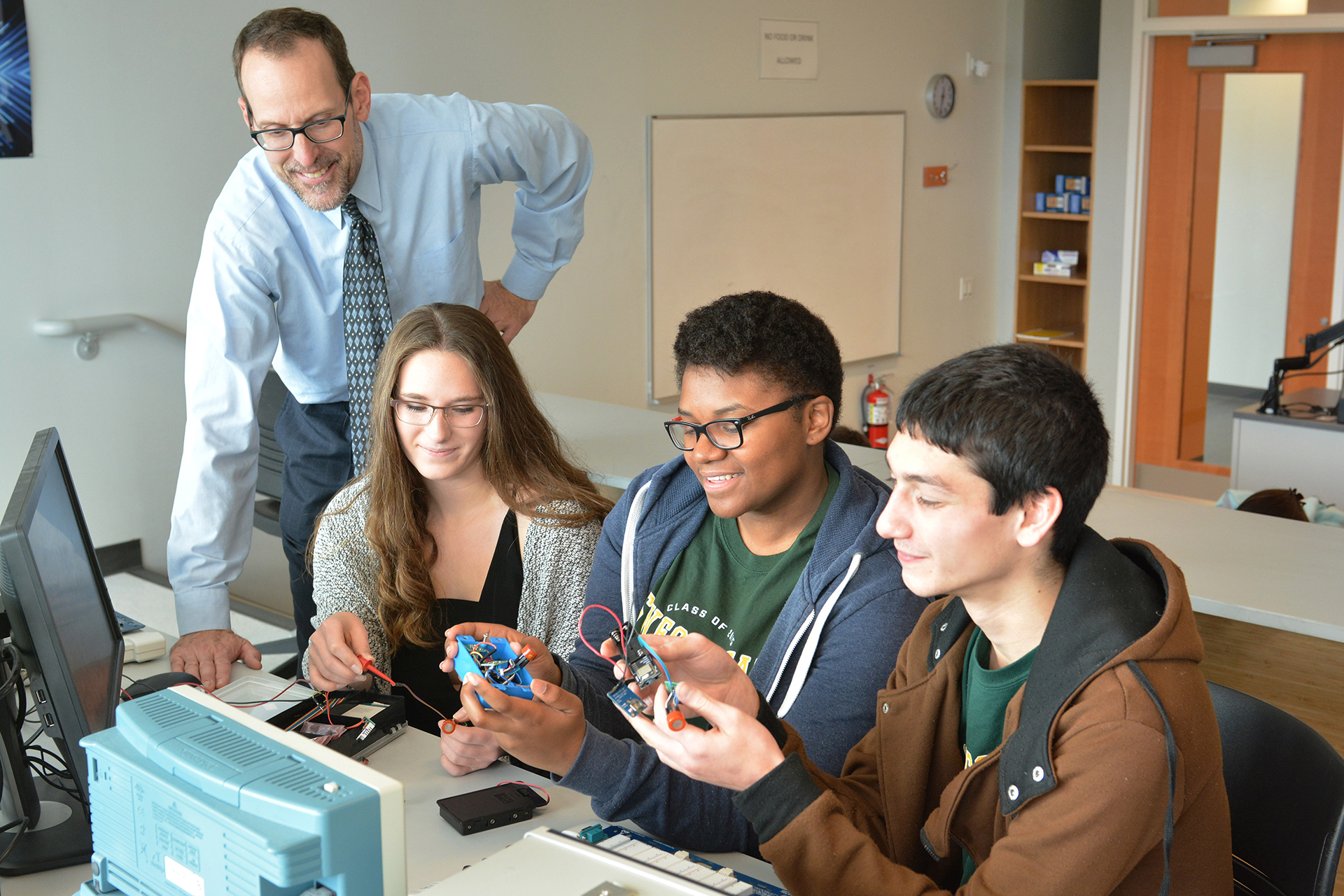 Students working on a project with a professor