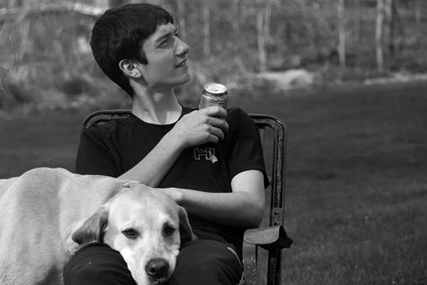 Student sitting with dog and looking outward