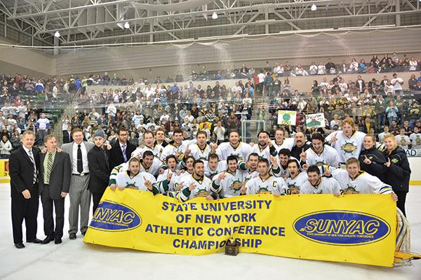 Hockey team holding SUNYAC championship banner