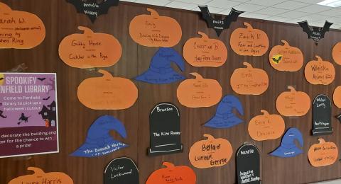 Halloween cutouts stuck on wall with book titles written on them