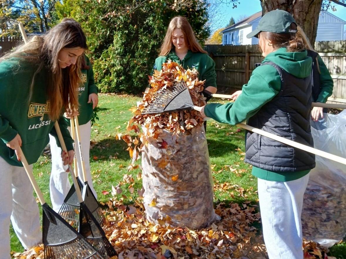 Members of the women's lacrosse team participate in Laker student-athletes' annual community service event raking leaves for local senior citizens.