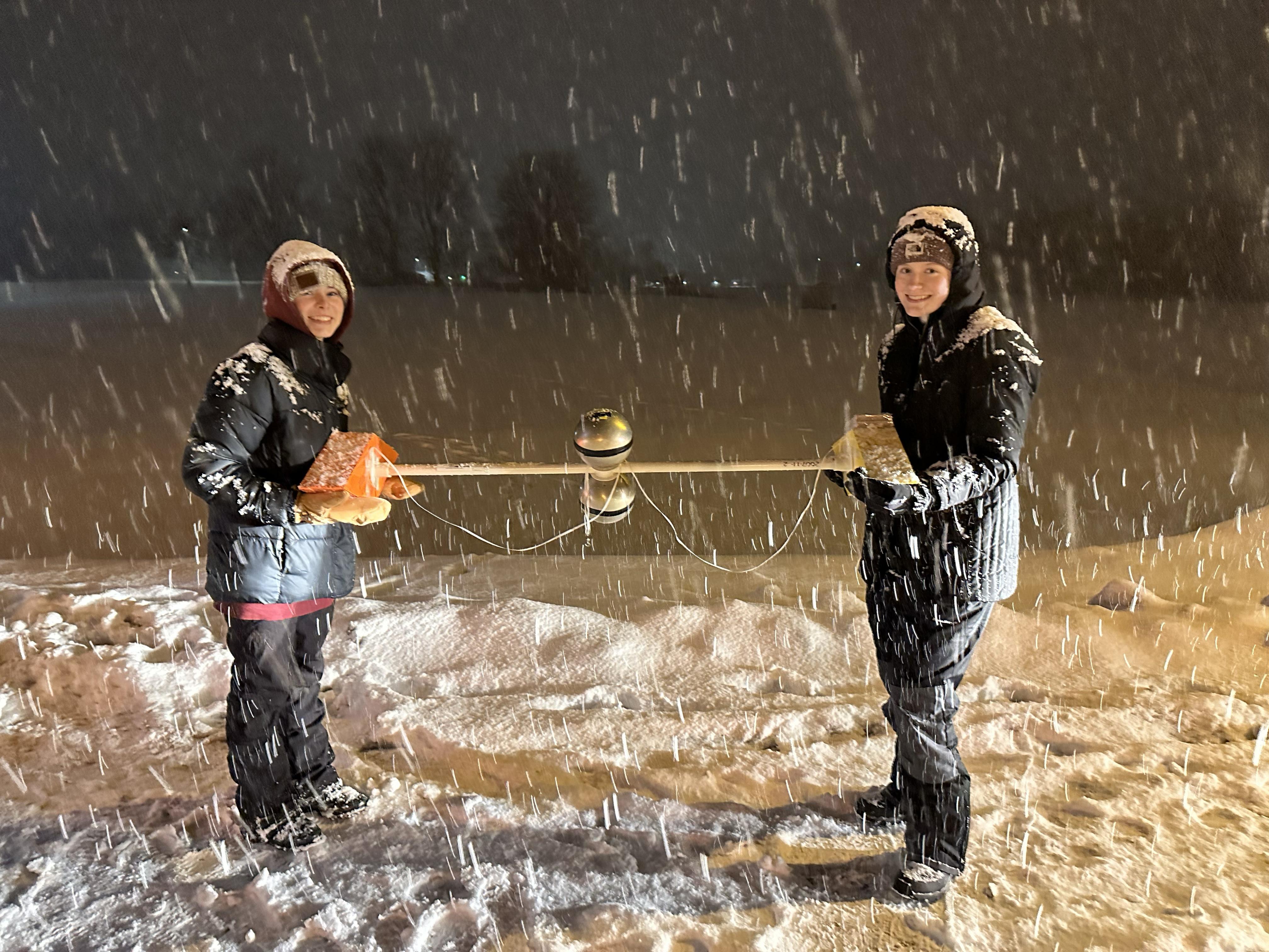 Student researchers (from left) Zoe Bush and Sarah Gryskewicz hold an electric field meter during research on lake-effect lightning