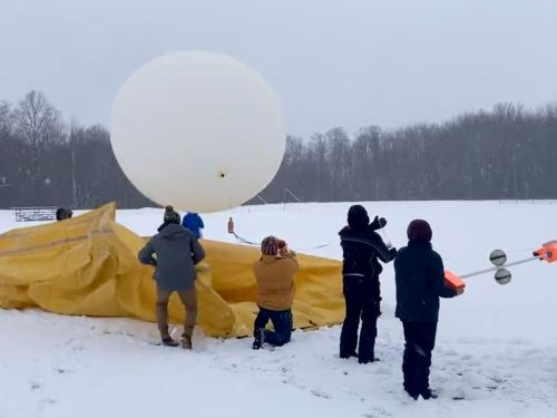 Students taking part in a lake-effect lighting study launch a huge weather balloon with attached instrumentation to measure conditions inside a winter storm cloud.