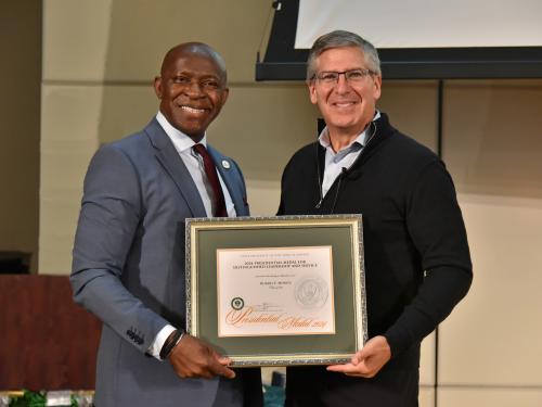 PHOTO CAPTION: SUNY Oswego President Peter O. Nwosu (left) presents Bob Moritz, Class of 1985, with the prestigious Presidential Medal during the inaugural Sheldon Lecture on Sept. 24.