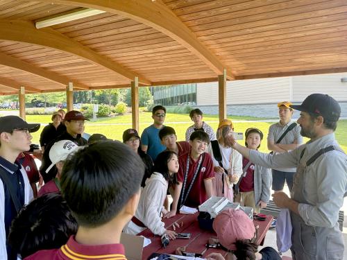 Biological science faculty member Daniel Baldassarre provides an ornithology lesson to visiting students from South Korea