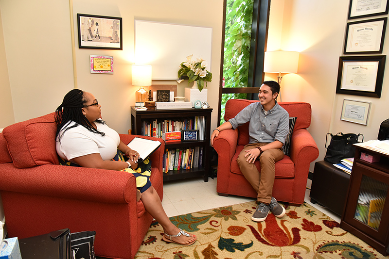 Cara Plasencia (left), of the Counseling Services Center, talks in her new office with colleague Kyle R. Dzintars
