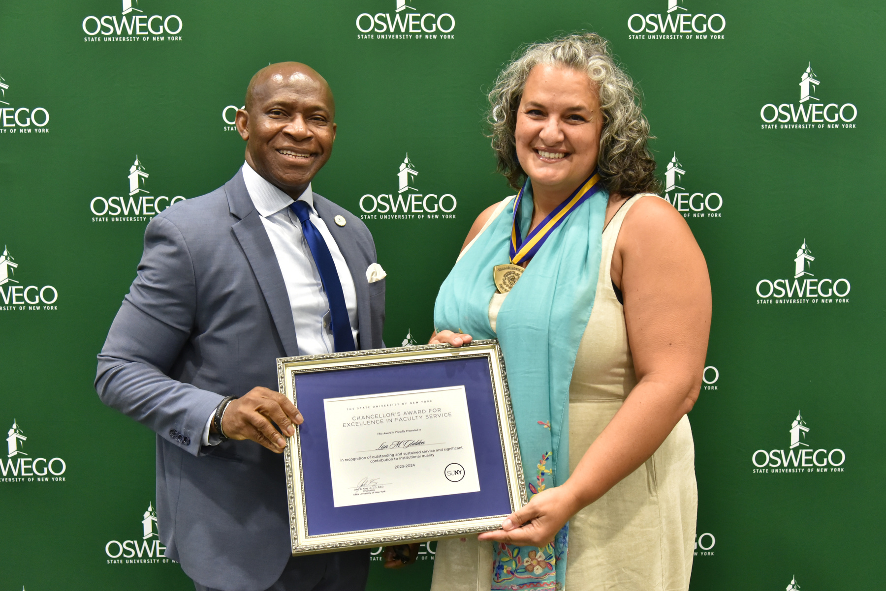 Politics professor Lisa Glidden receives her Chancellor's Award for Excellence in Faculty Service and congratulations from President Peter O. Nwosu at the Opening Breakfast. Watch Oswego Today for a full story on her award.