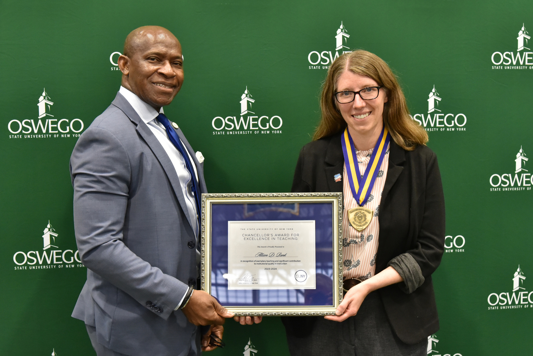 Politics faculty member Allison Rank receives her Chancellor's Award for Excellence in Teaching and congratulations from President Peter O. Nwosu at the Opening Breakfast. Watch Oswego Today for a full story on her award.