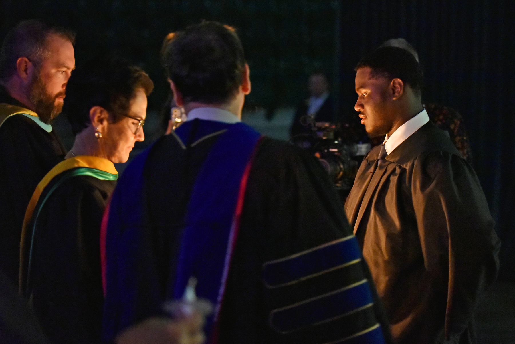 Torchbearer Aiden Wilson, a senior and Student Association president, lights the candle held by Vice President for University Advancement Mary Canale ’81. 