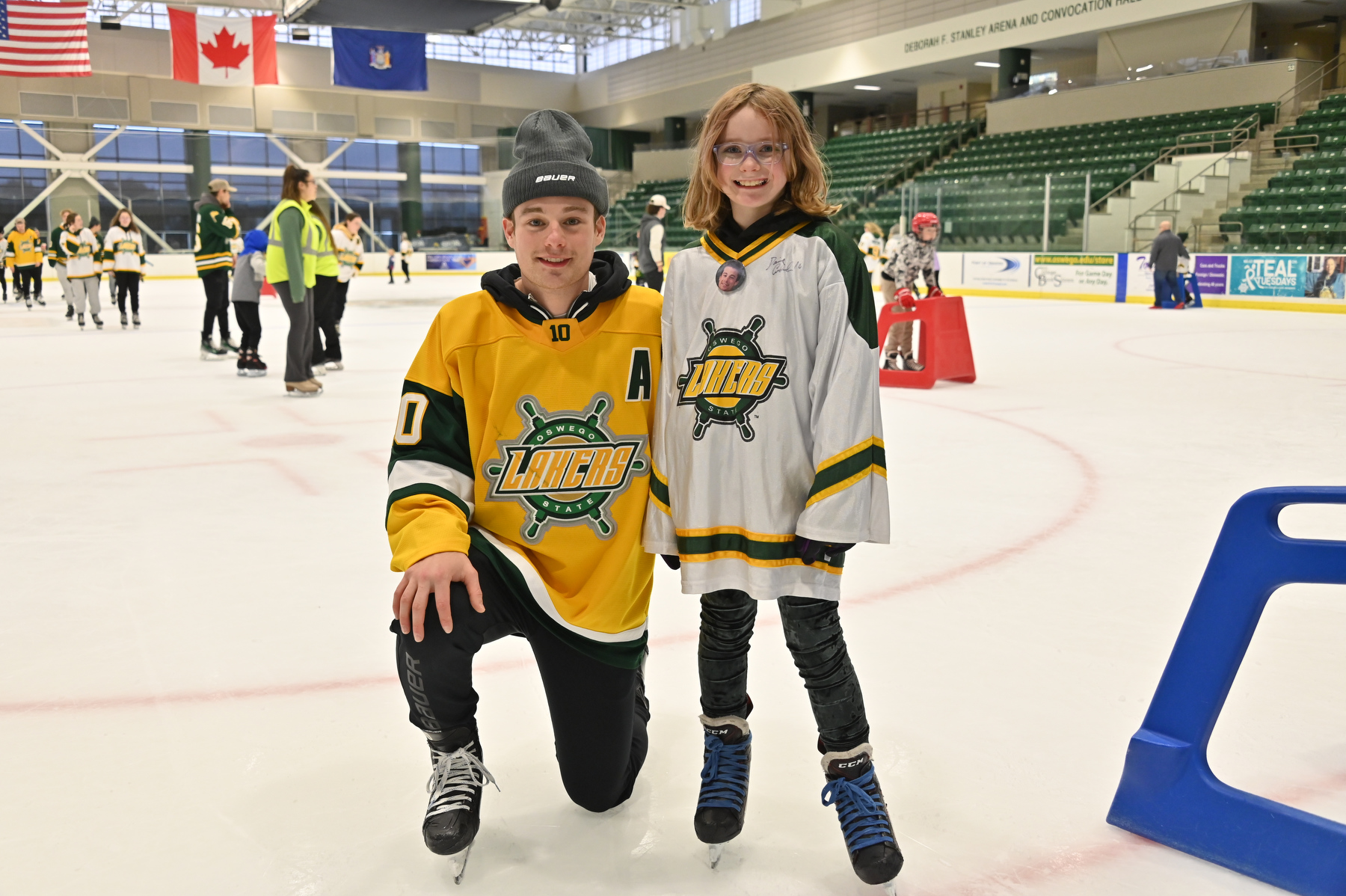 Raelyn Burchim, age 9, takes a photo with Laker senior Daniel Colabufo (#10) at the Holiday Skate with the Lakers. Burchim's father is currently deployed in Iraq serving with the U.S. Army.