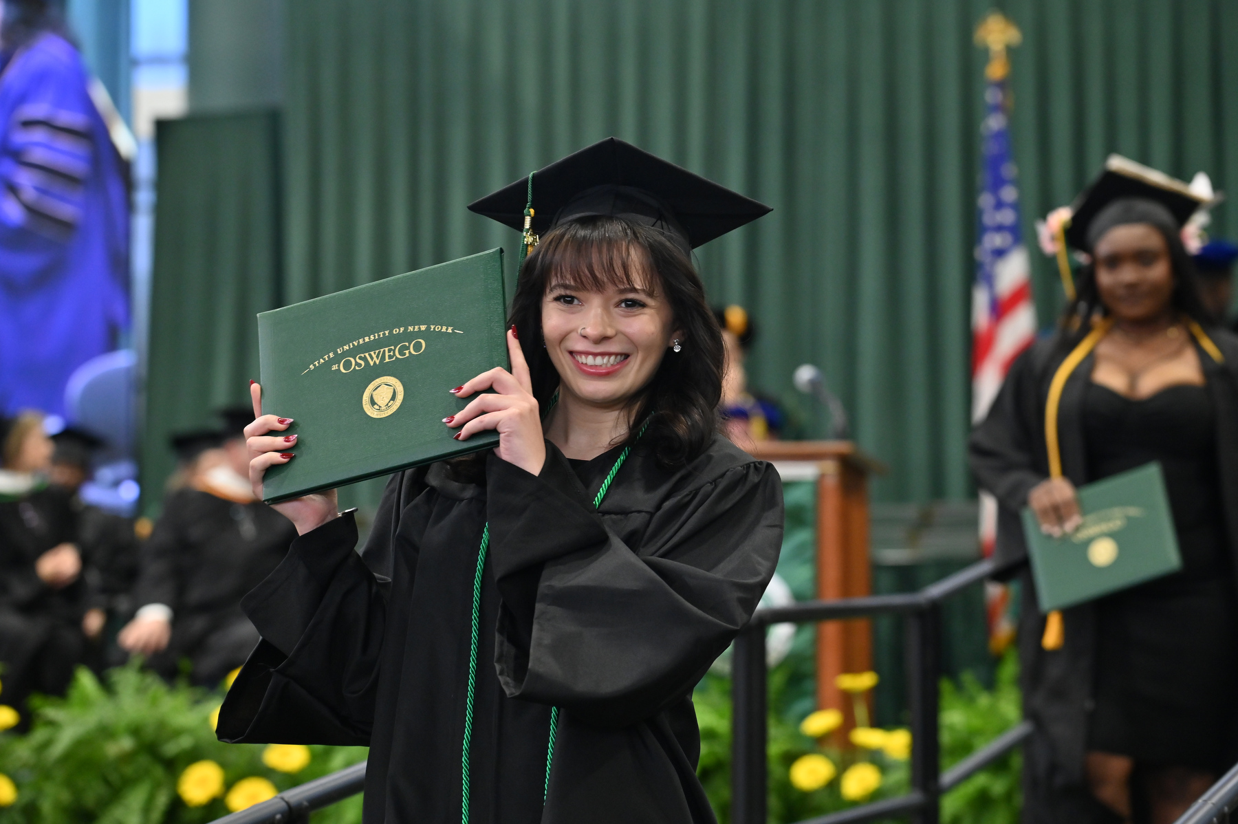 Vanessa Barron smiles while walking the Commencement stage.