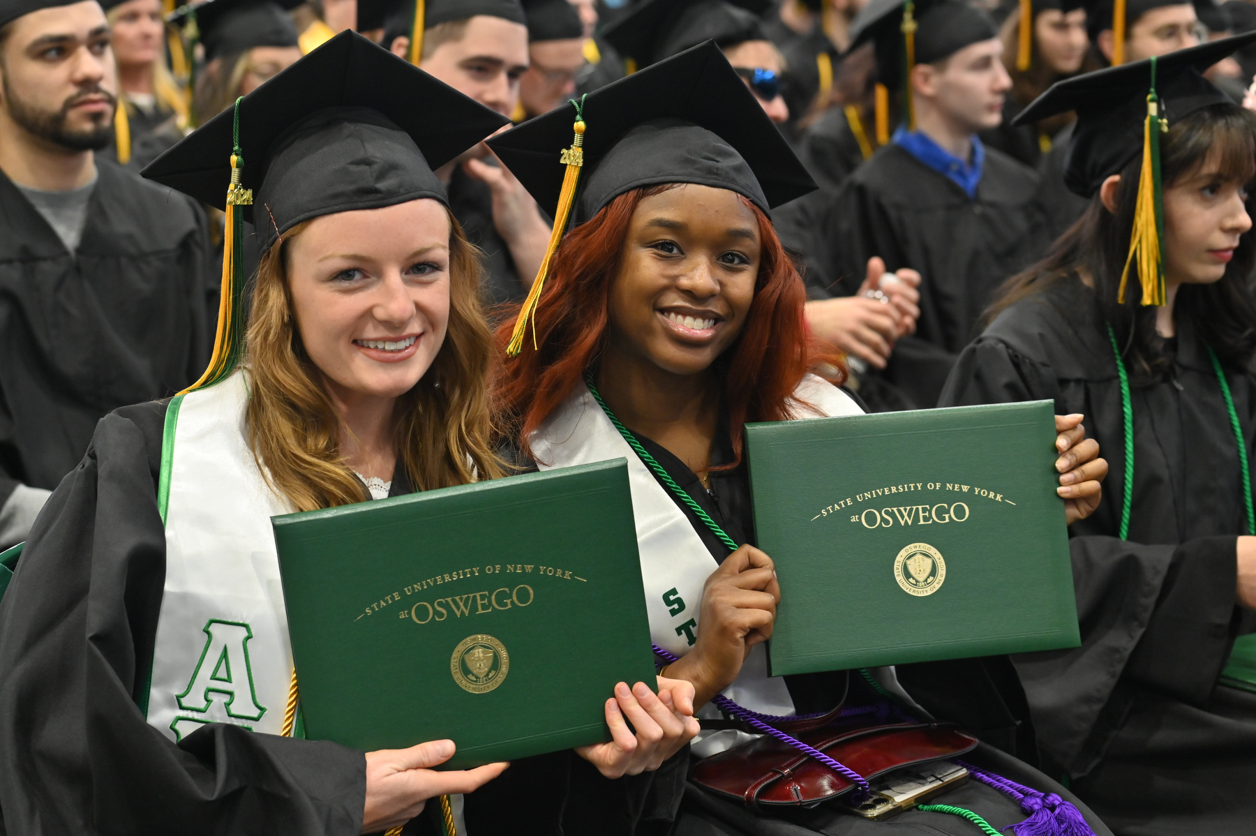 Taylor Farrell (left) and Nyah Dias celebrate receiving their degrees at Commencement.