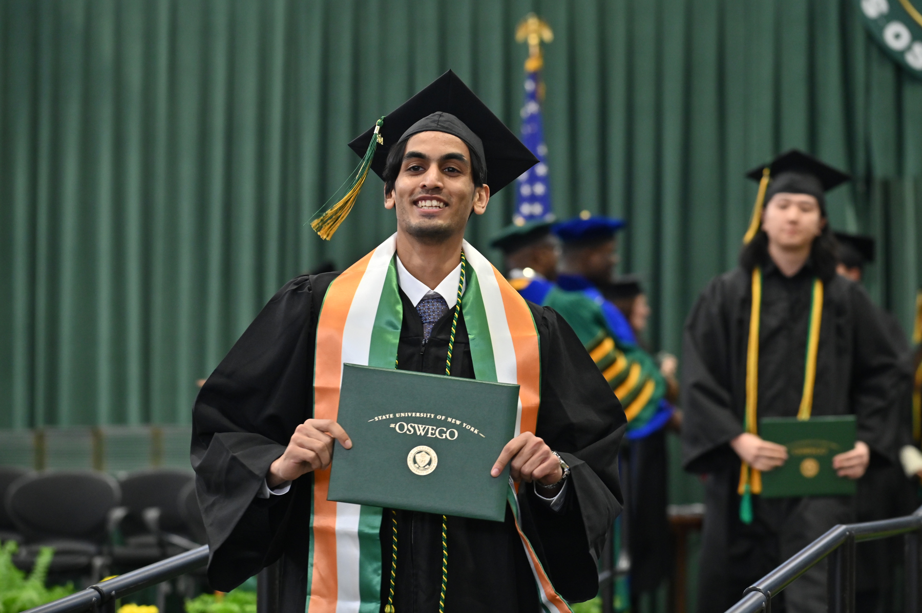 Harshit Gupta smiles while walking the ramp during Commencement.