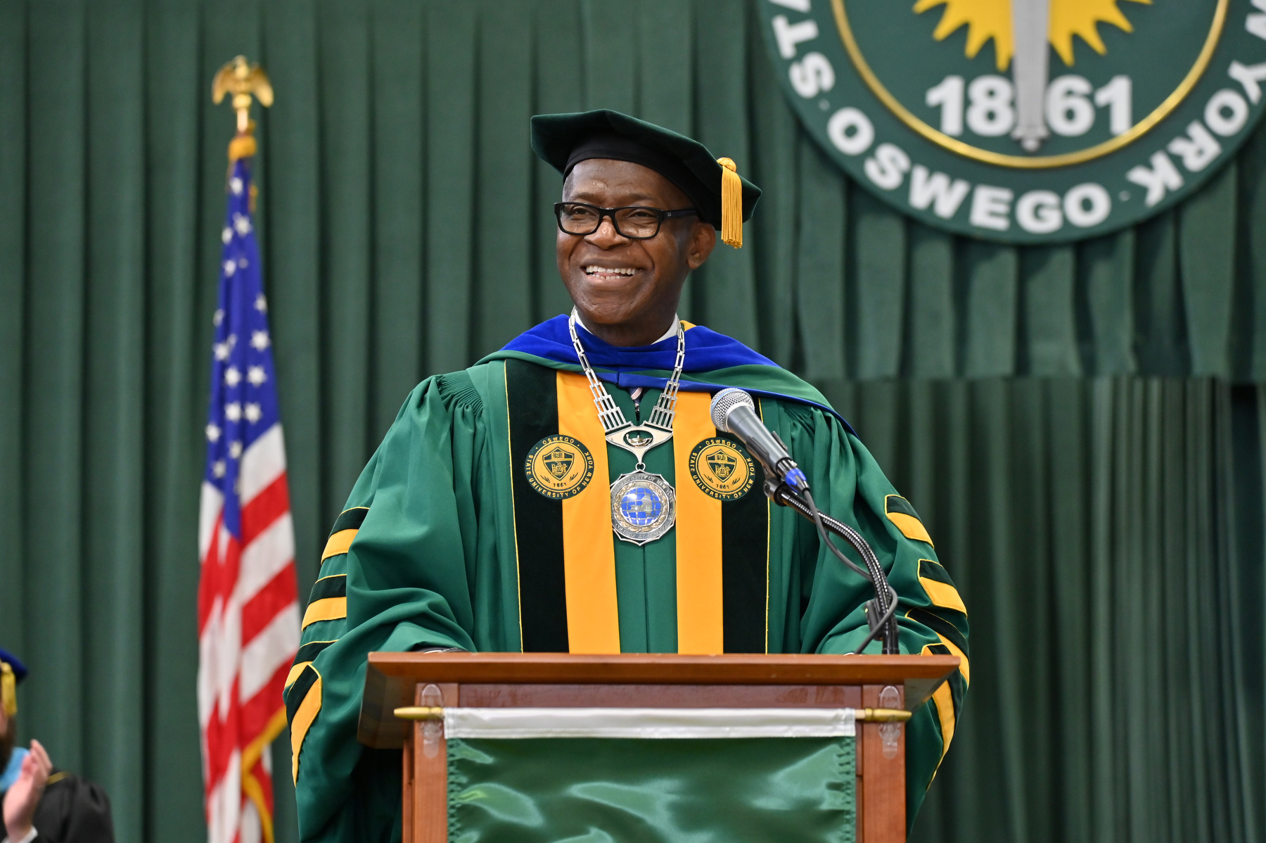 University President Peter O. Nwosu enthusiastically congratulates the graduates from the platform at Commencement on Dec. 14 in the Deborah F. Stanley Arena and Convocation Hall.