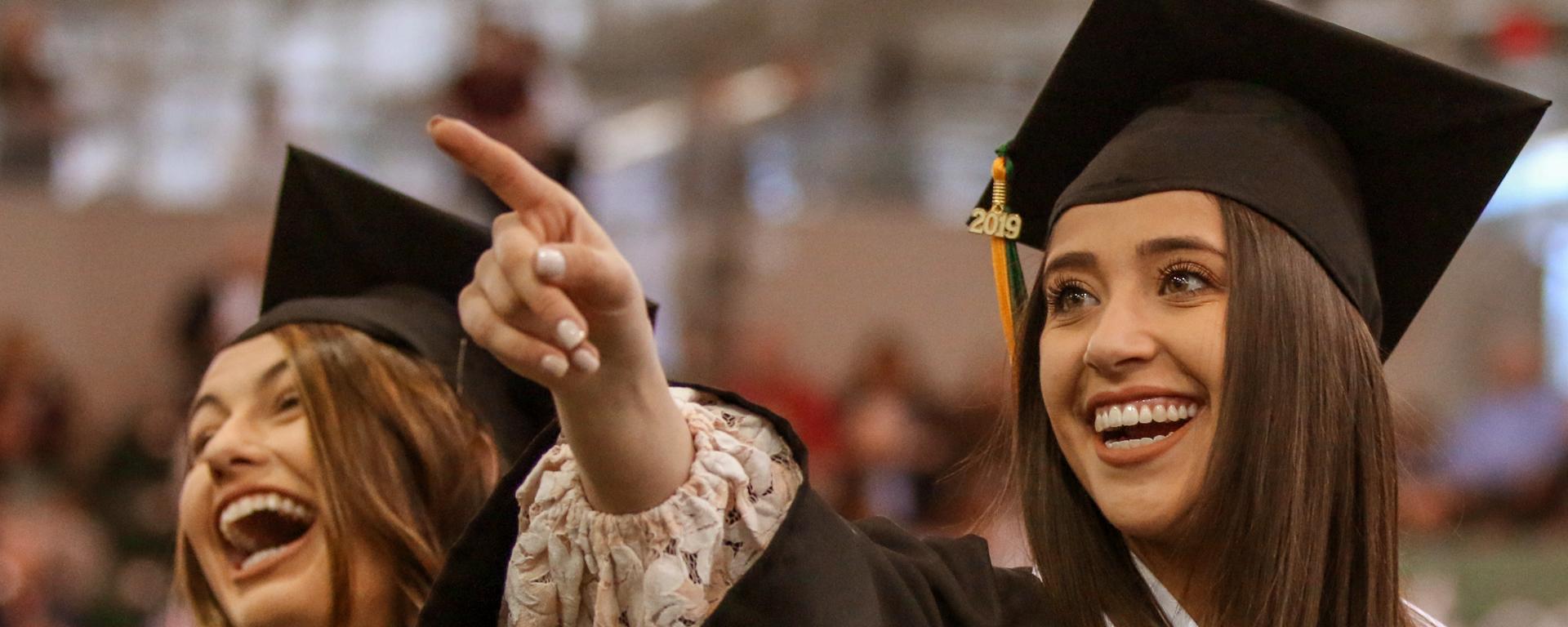 Student points to audience during Commencement